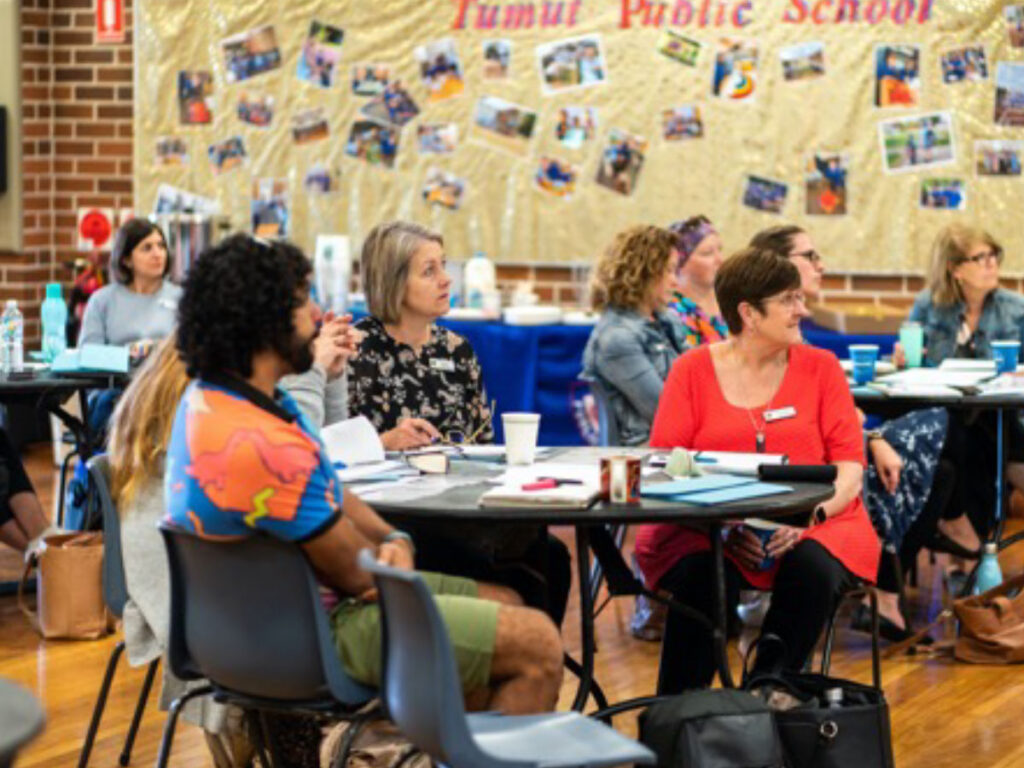 Literacy leaders collaborating at tables during a school workshop