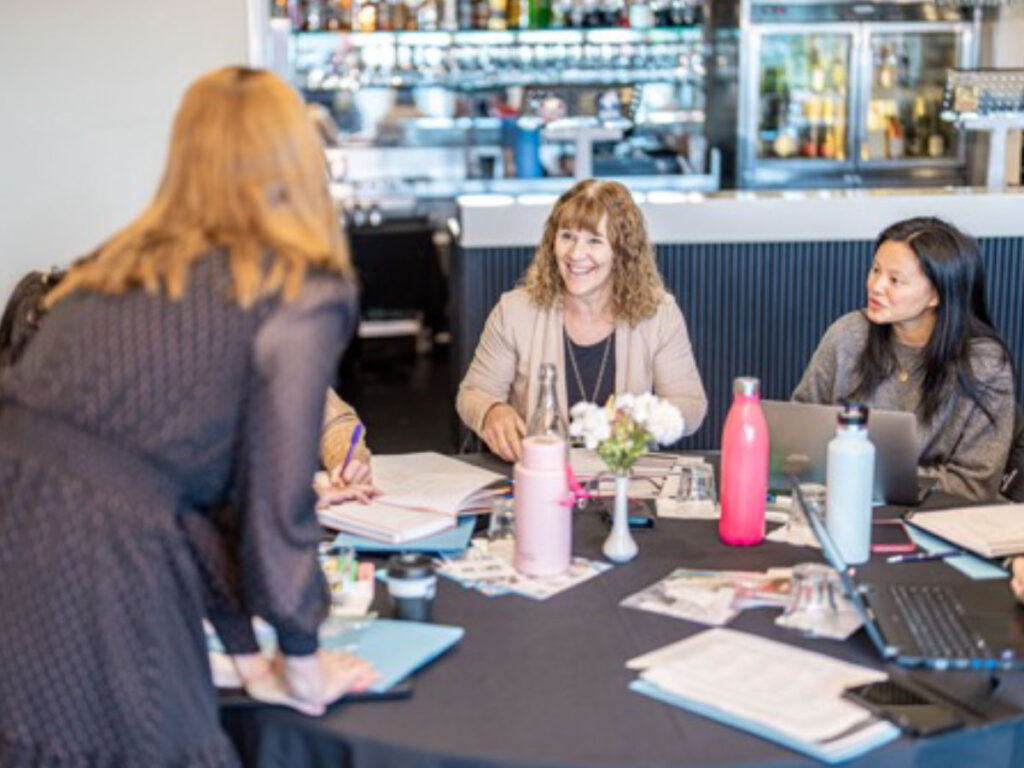 School leaders meeting around a table with notes and laptops