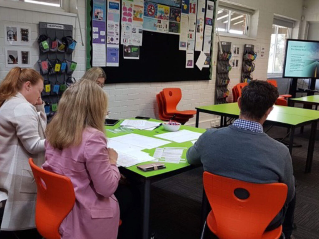 Teachers working together at tables in a school staff room